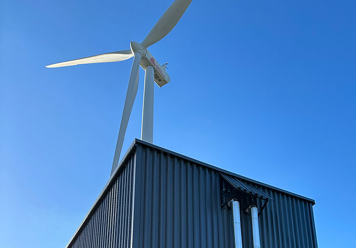 ThermalBattery™ von ENERGYNEST mit Windkraftanlage auf Produktionsgelände von Avery Dennison