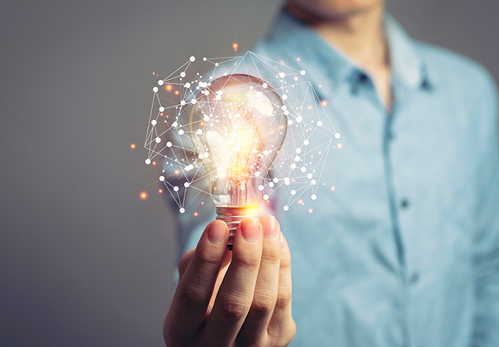 Mann im Hintergrund hält Glühbirne