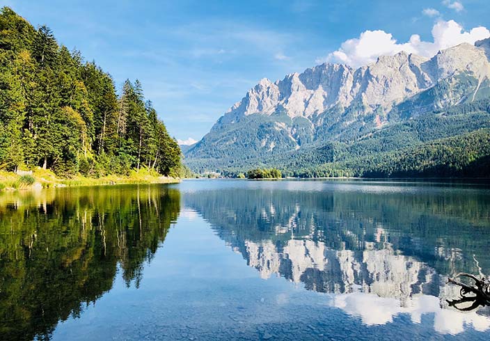 Landschaft mit Bergen, Wald und See