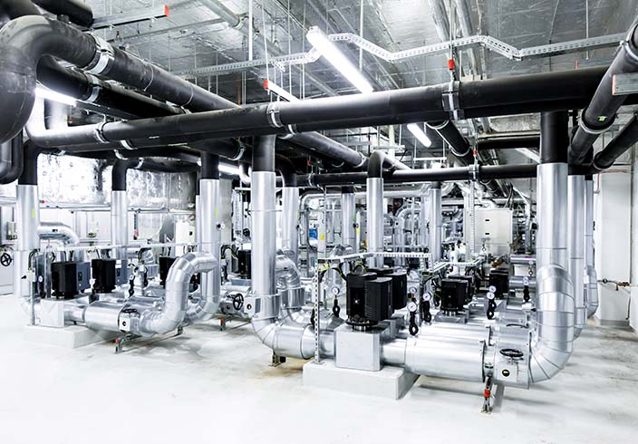 Wärme speichern in industrieller Anlage mit isolierten Rohrleitungen und Technikmodulen