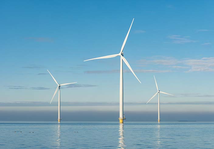 Offshore-Windpark im Meer vor blauem Himmel